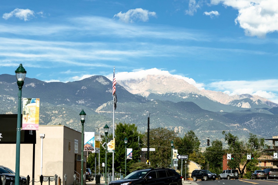 Pikes Peak rising above a downtown street on a clear day