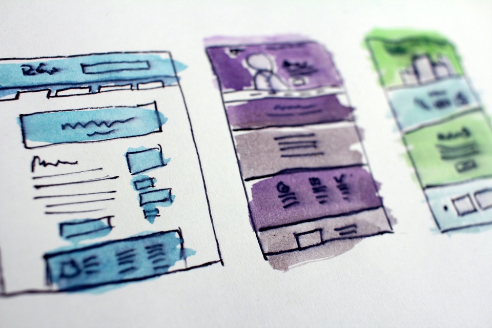 Watercolor wireframe sketches of three website page layouts